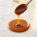 Golden caramel filling falling in a thick ribbon from a spoon